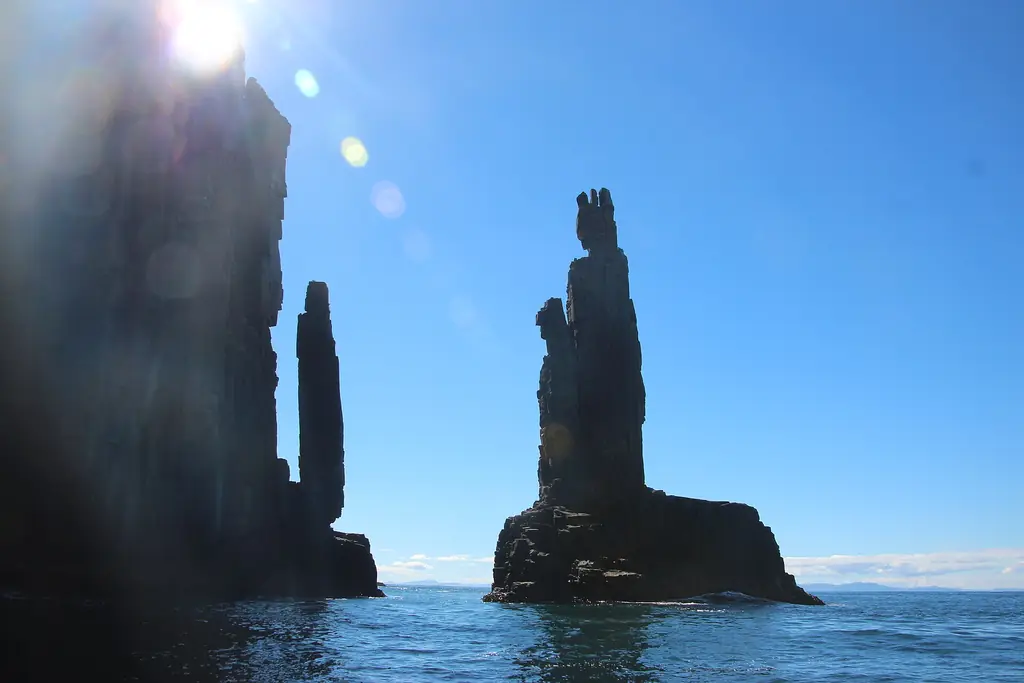 A Bruny Island wilderness cruise boat beneath tall sea cliffs